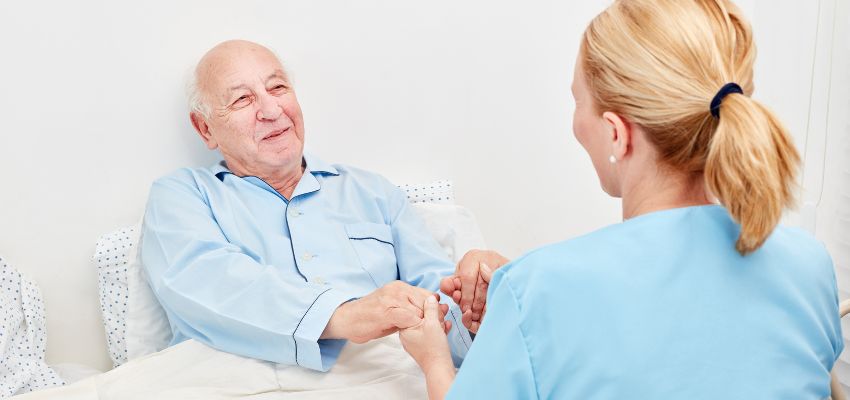 The aged man feels happy and relieved because the caregiver cares for him well.