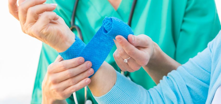 The nurse dressed the stitches on the patient's arm.