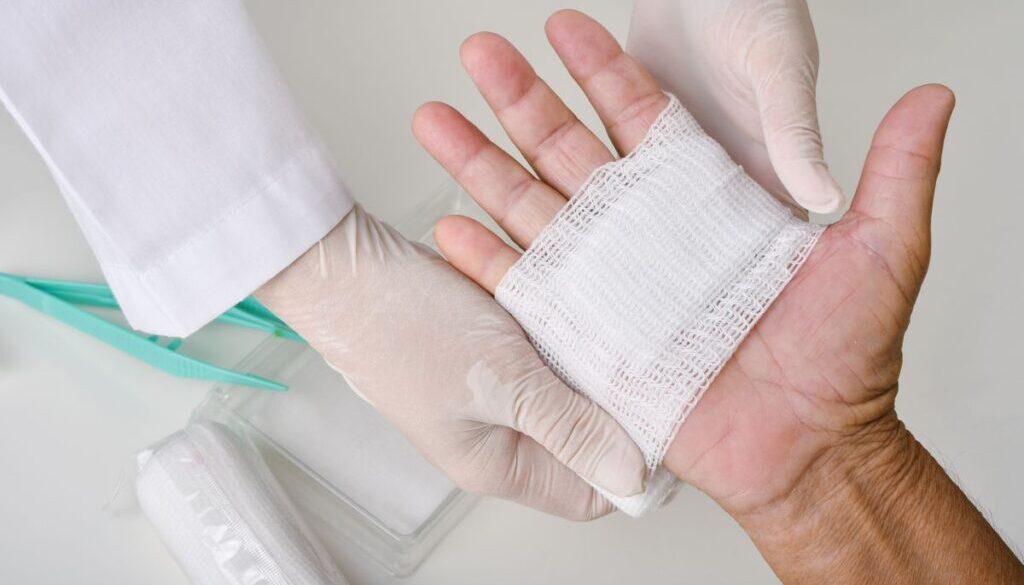 The caregiver cleans and dresses the patients' wounds.