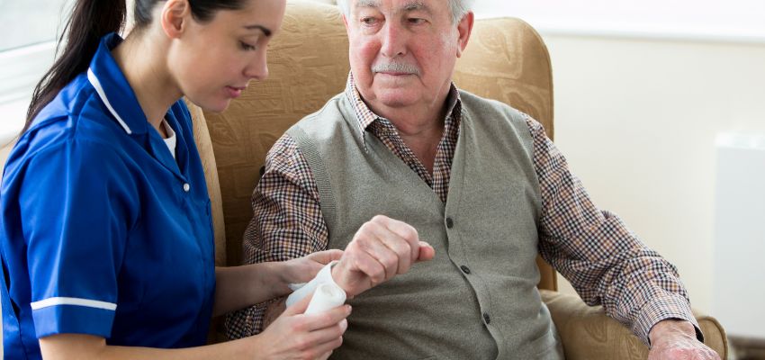 The caregiver treats the man's tunneling pressure ulcers.