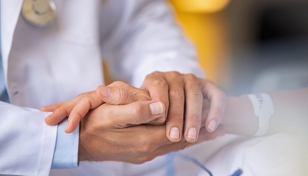 The doctor holds the hands of the patients with chronic wounds.