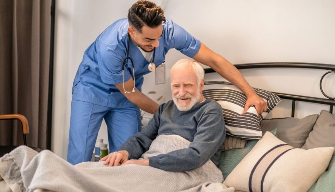 The caregiver helps the elderly patient change position to avoid pressure sores.