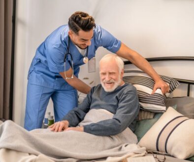 The caregiver helps the elderly patient change position to avoid pressure sores.