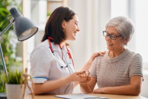 The doctor happily discusses how regenerative medicine treatment can help the older woman.