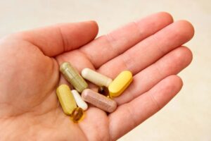 The man holds vitamins that are good for wound healing.