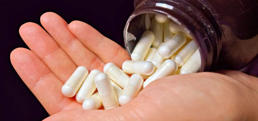 The man examines the bottle of vitamins that are good for wound healing.